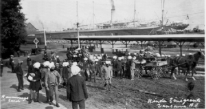 1907. East Indian immigrants (mostly Sikhs) landing in Canada at the CPR Pier, loading possessions onto horse-drawn wagons.